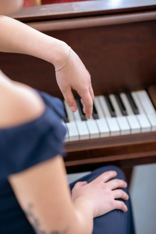 a woman in a blue dress playing a piano, trending on unsplash, laying down with wrists together, student, high angle close up shot, digitally remastered