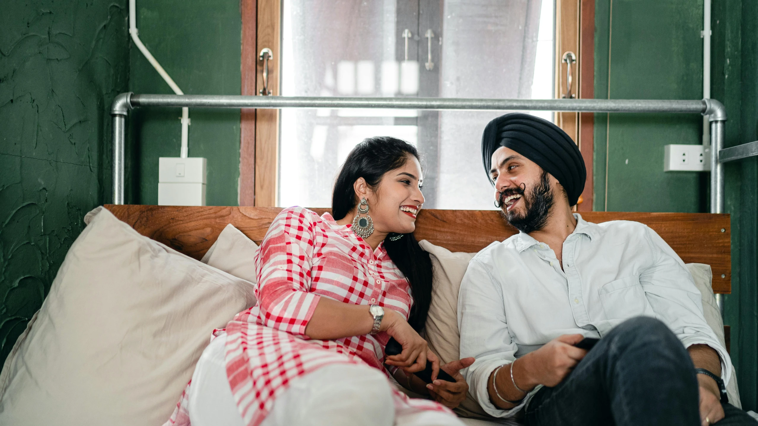 a man and a woman sitting on a bed, inspired by Manjit Bawa, pexels contest winner, sitting on a couch, flirting smiling, full device, indian