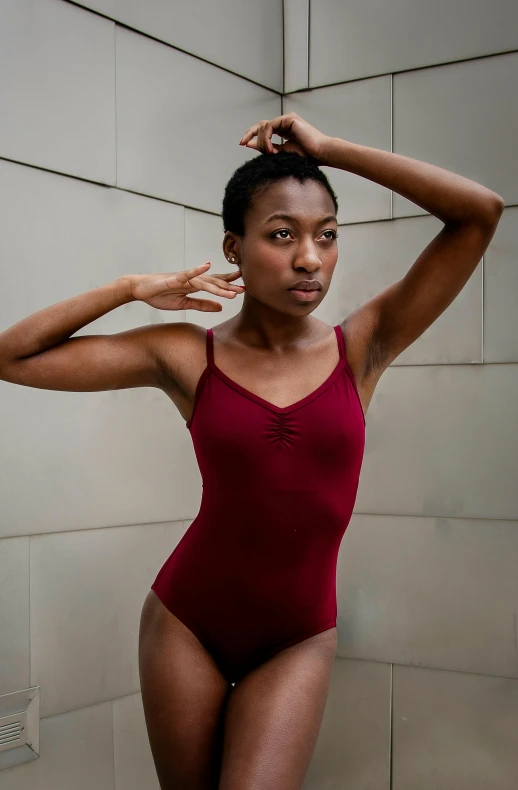 a woman in a red bodysuit posing for a picture, inspired by Elizabeth Polunin, pexels contest winner, brown skinned, wearing leotard, maroon, pose 4 of 1 6