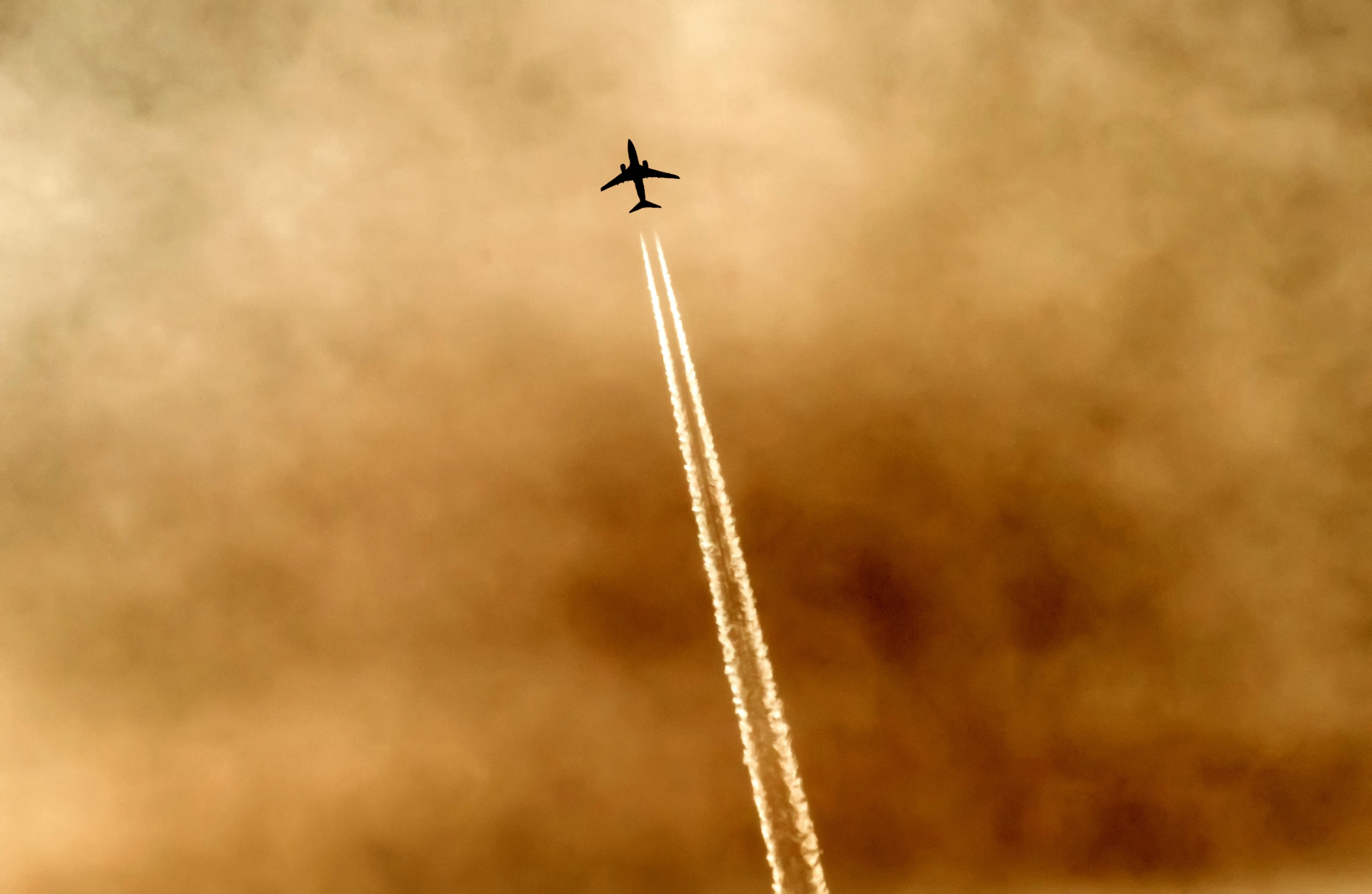 a large jetliner flying through a cloudy sky, a picture, by Paul Bird, pexels contest winner, precisionism, sandstorm, a wooden, trail of smoke, low angle!!!!