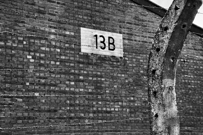 a black and white photo of a brick building, a photo, inspired by Ib Eisner, flickr, graffiti, rule of three, detention centre, 1 3 3 4 building, old signs