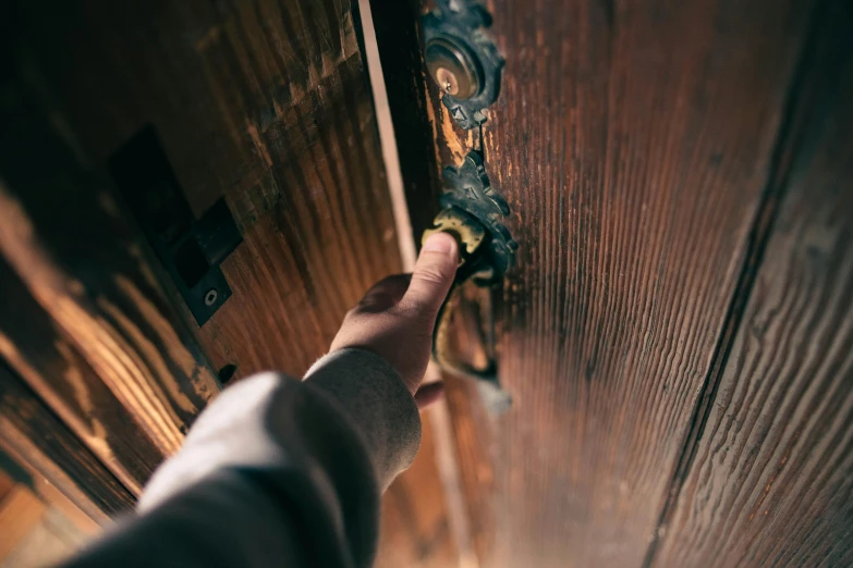 a person opening a wooden door with a handle, pexels contest winner, ornate declotage, lit from above, well worn, under repairs