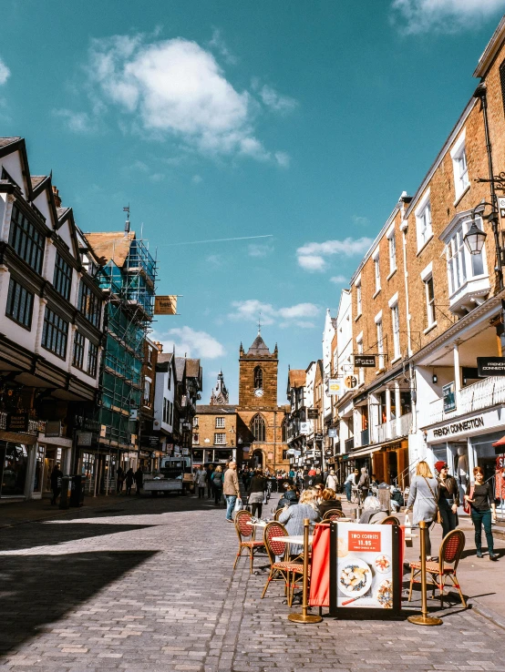 a group of people walking down a street next to tall buildings, arts and crafts movement, warwick saint, people sitting at tables, 🤬 🤮 💕 🎀, today\'s featured photograph 4k