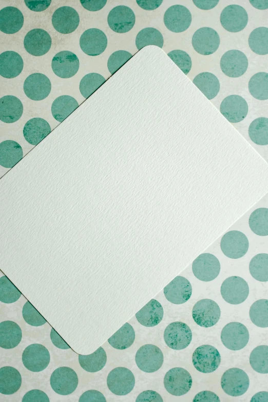 a piece of paper sitting on top of a table, a minimalist painting, inspired by Rachel Whiteread, unsplash, stippling dots, seafoam green, comic card style, background is white and blank