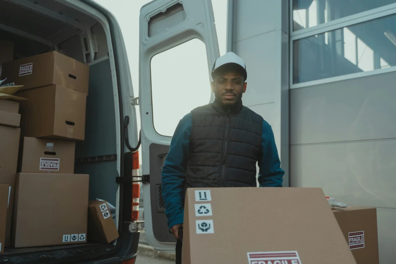 a man standing next to a van filled with boxes, pexels contest winner, renaissance, black man, avatar image, people at work, trading depots