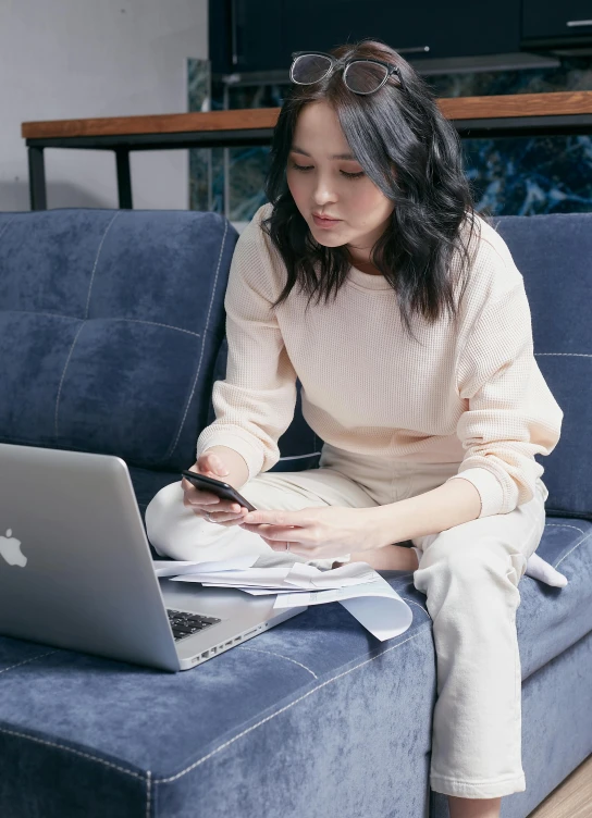 a woman sitting on a couch using a laptop, inspired by Fei Danxu, trending on pexels, happening, wearing off - white style, checking her phone, office clothes, ( ( theatrical ) )