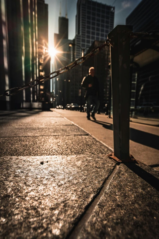 a person riding a skateboard down a sidewalk, by Andrew Domachowski, pexels contest winner, nighttime in gotham city, dormant in chains, light glare, pitch darkness around the post