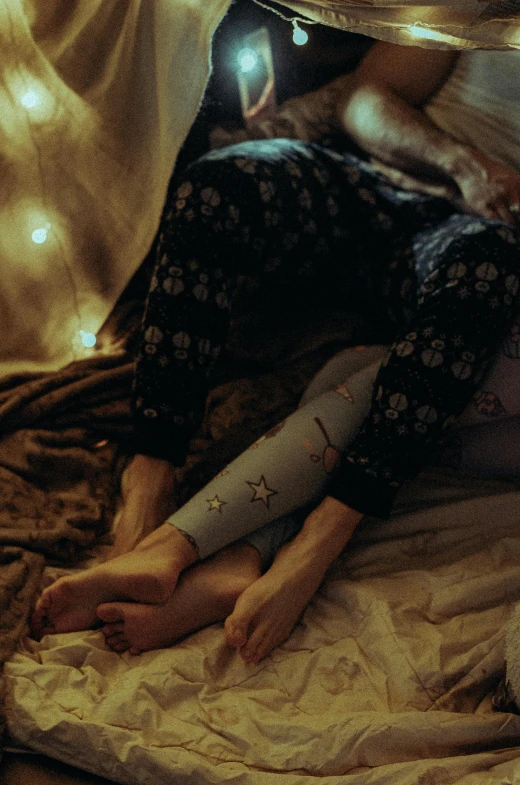 a couple of people laying on top of a bed, inspired by Elsa Bleda, trending on pexels, renaissance, white tights covered in stars, leggings, embroidered velvet, holiday season