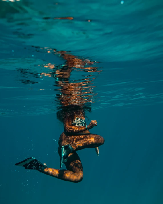 a person that is in the water with a surfboard, by Emma Andijewska, unsplash contest winner, sumatraism, golden fish in water exoskeleton, brown and cyan blue color scheme, sassy pose, conde nast traveler photo