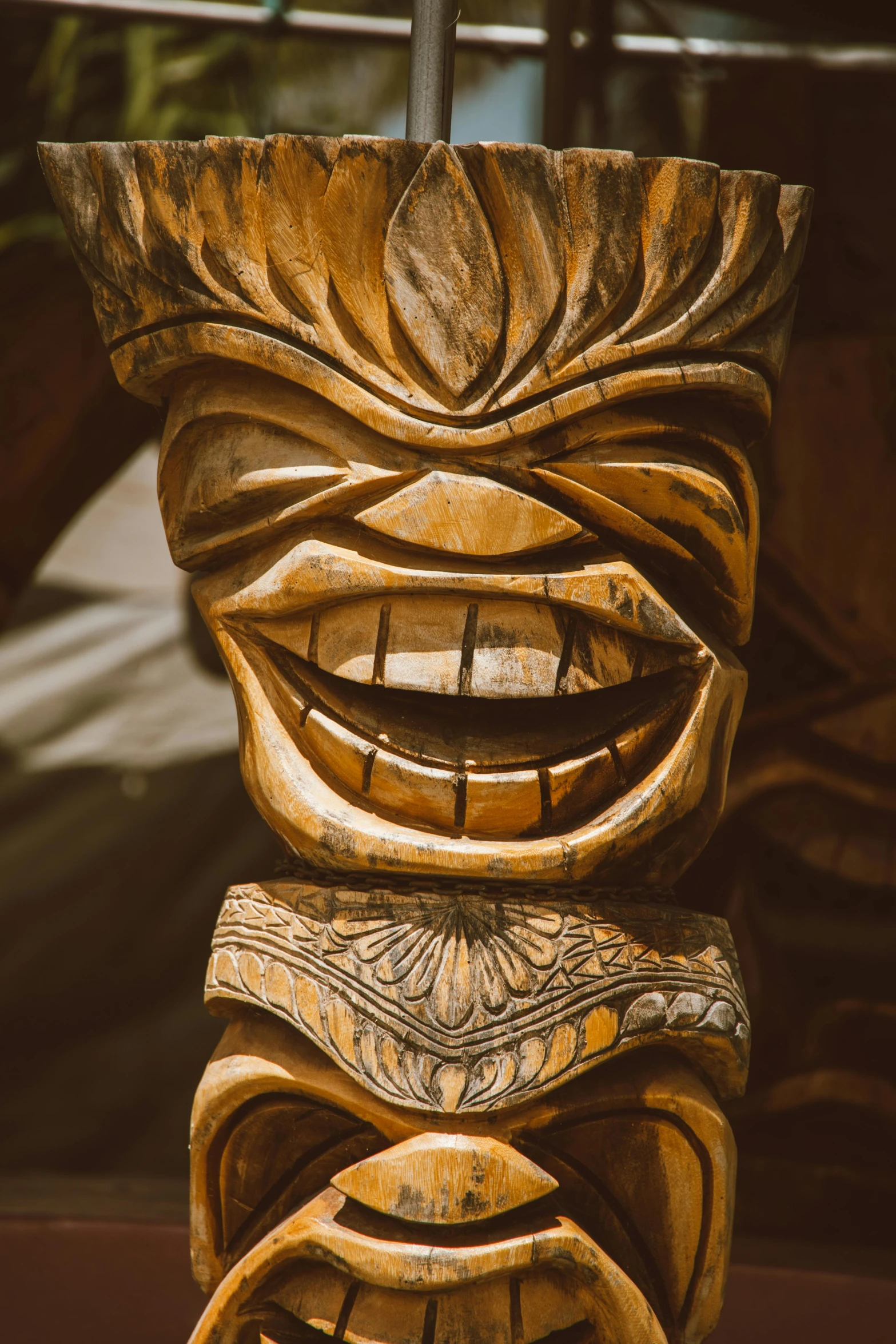 a wooden tiki sitting on top of a table, clenching teeth, up close, tribal ancient imagery, smiley