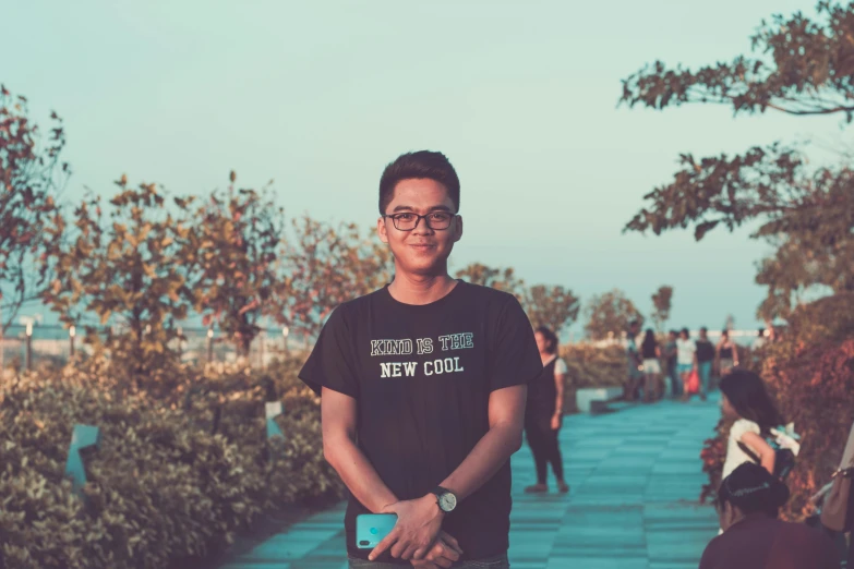 a man standing in front of a group of people, a picture, by Bernardino Mei, unsplash, with a park in the background, avatar image, teen boy, slight nerdy smile