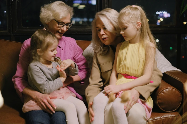 a woman sitting on a couch with two little girls, pexels, realism, white-haired, video footage, close to night, looking at each other mindlessly
