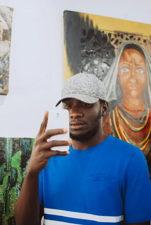 a man taking a selfie in front of a painting, a picture, by Chinwe Chukwuogo-Roy, trending on pexels, christian saint, with grey skin, avatar image, phone in hand