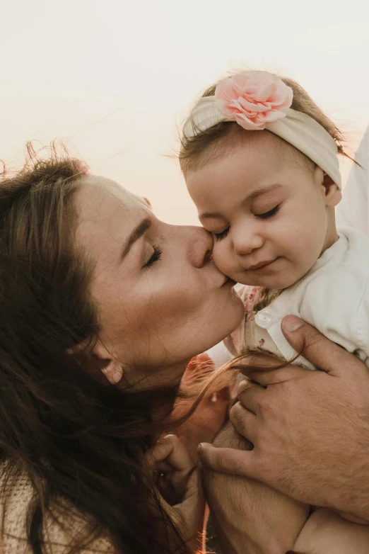 a close up of a person kissing a baby, pexels contest winner, symbolism, woman holding another woman, happy family, brazil, profile image