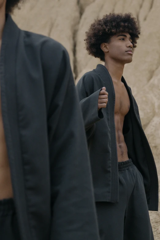 a couple of men standing next to each other, trending on unsplash, renaissance, thin black robe, black teenage boy, shirtless, karate outfit