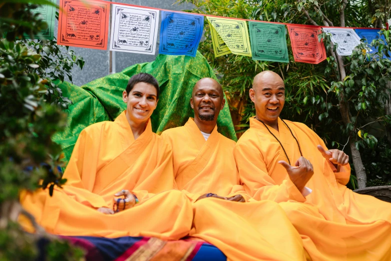 a couple of men sitting next to each other, pexels contest winner, gutai group, monk clothes, brightly coloured, the three moiras, triumphant pose