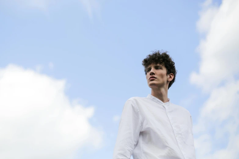 a man in a white shirt and black pants, pexels contest winner, looking upwards, genderless, curls on top, partly cloudy