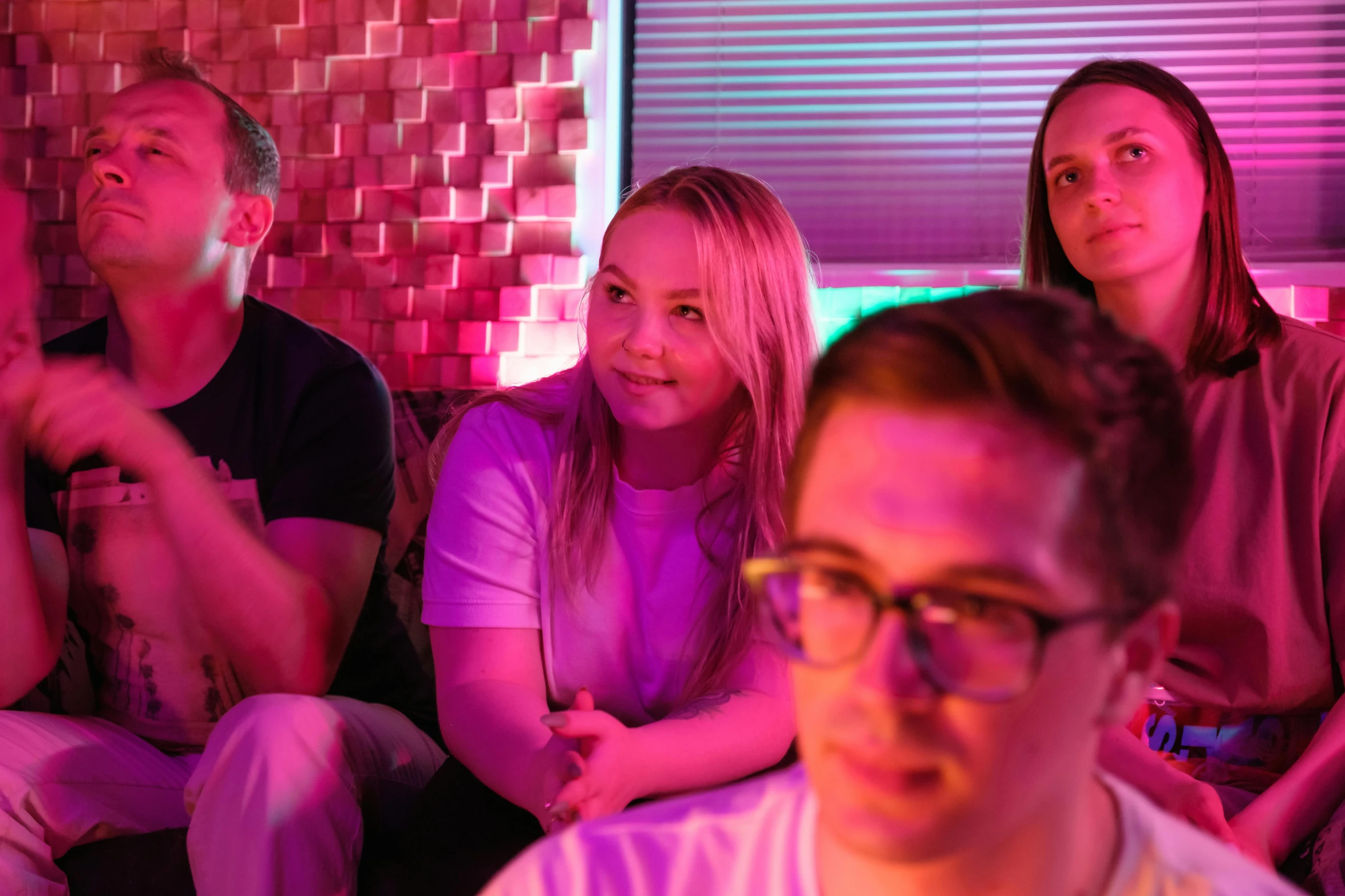 a group of people sitting on top of a couch, a portrait, pexels, happening, neon lights in the background, sydney sweeney, bottom angle, profile image