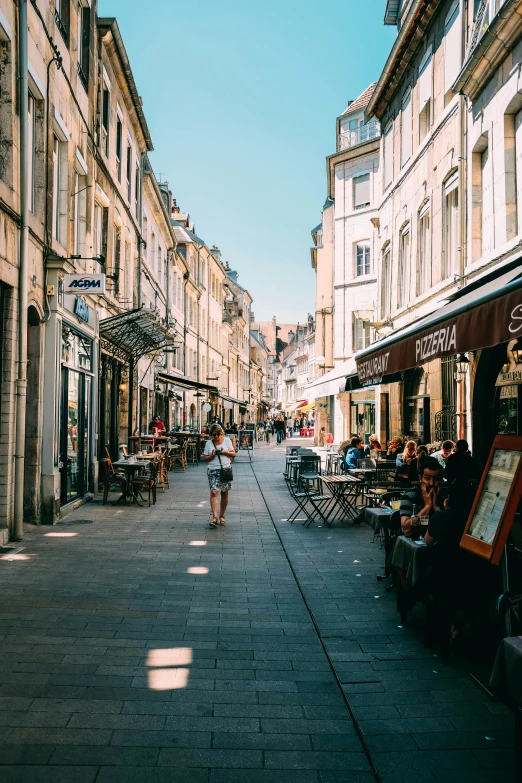 a group of people walking down a street next to tall buildings, renaissance, french architecture, stores, eating outside, beautiful small town