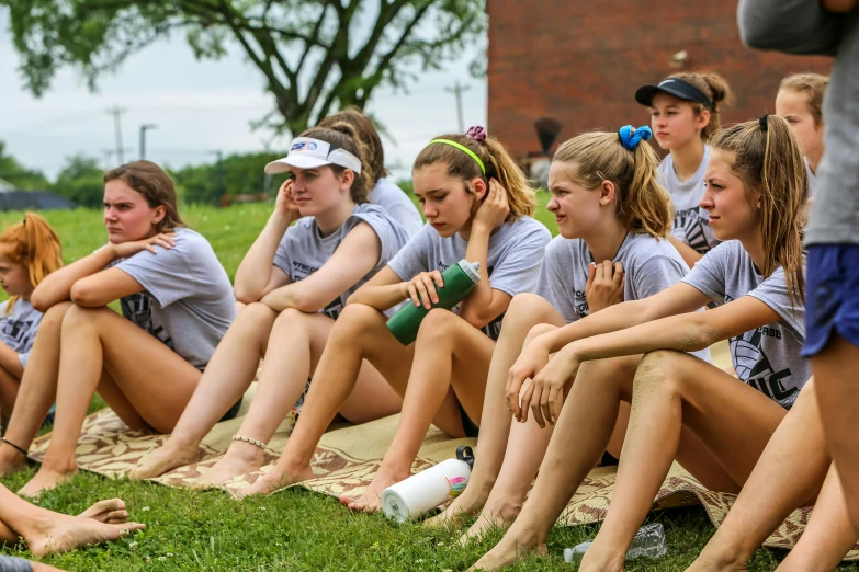 a group of women sitting on top of a lush green field, tournament, profile image, crewson photography, sweating hard