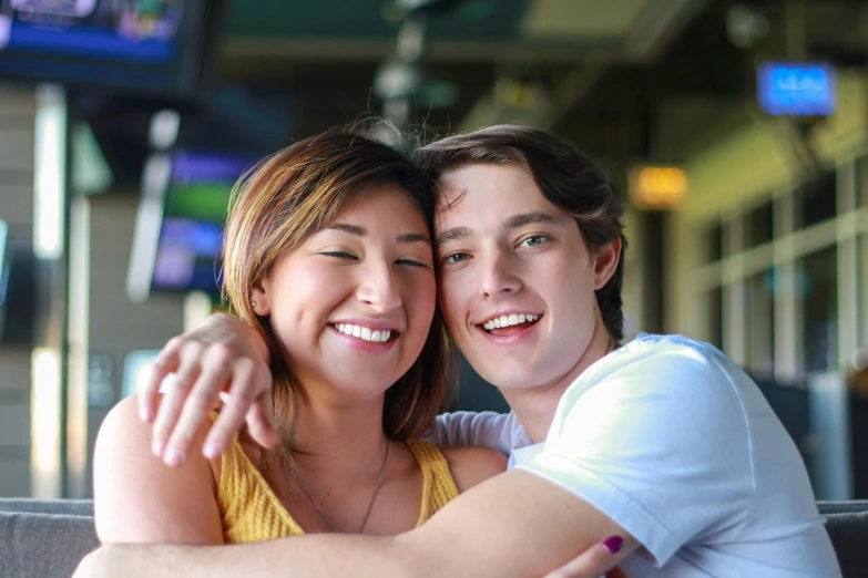 a man and a woman sitting next to each other, jordan grimmer and natasha tan, teen boy, background image, smiling couple