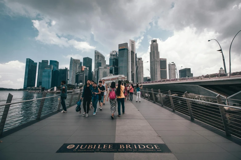 a group of people walking across a bridge, by Joseph Severn, pexels contest winner, happening, singapore city, subtitles, petite, 1 2 9 7