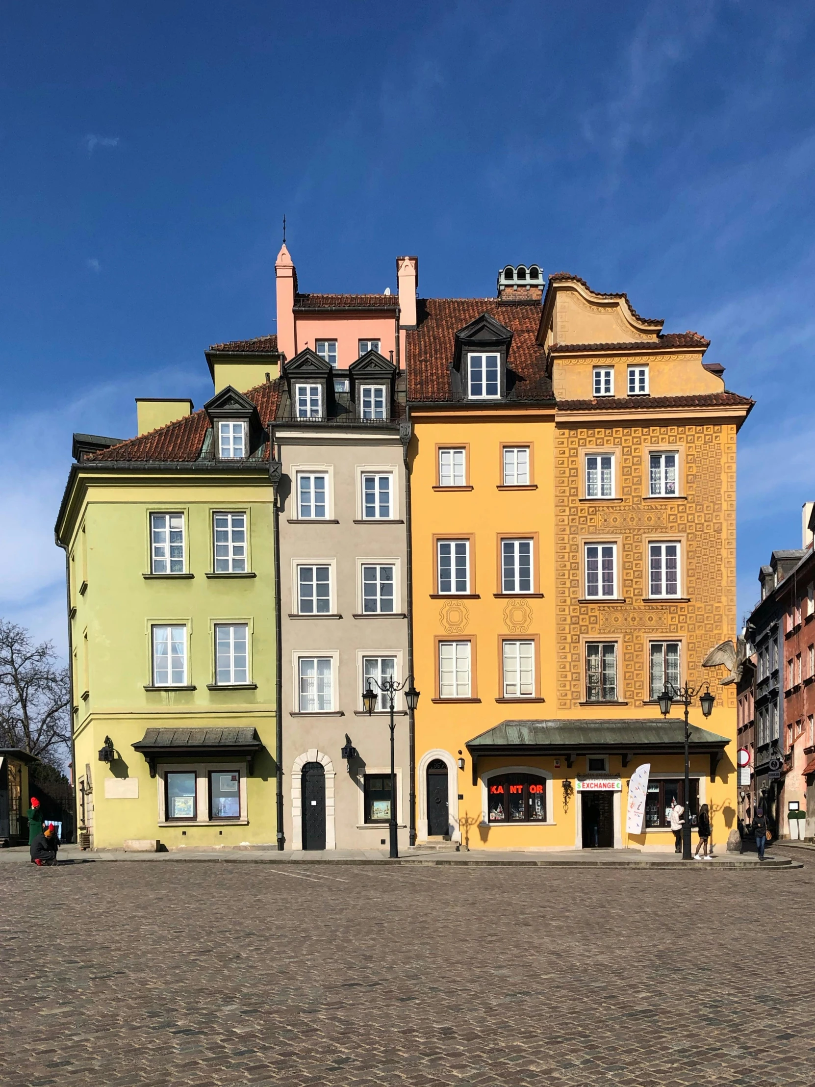 a group of buildings sitting on top of a cobblestone street, warsaw, yellow and green scheme, 2022 photograph, market square