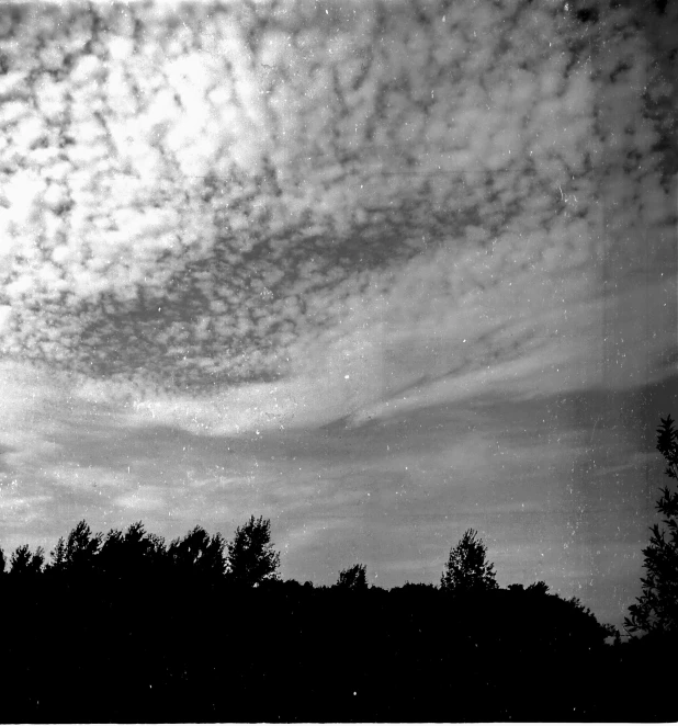 a black and white photo of a cloudy sky, holga 120n, starry, early evening, 3 5 mm grainy film