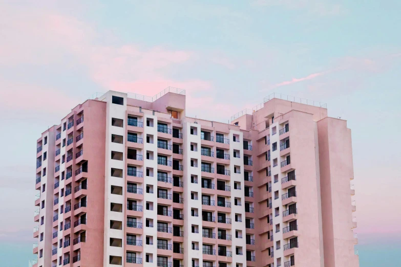 a tall building sitting on top of a lush green field, a colorized photo, pexels contest winner, modernism, pastel pink concrete, mumbai in the future, balconies, pastel palette silhouette