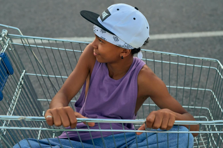 a young boy sitting in a shopping cart, pexels contest winner, graffiti, white cap, black teenage girl, light blue skin, purple