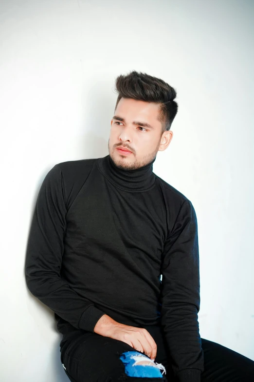 a man sitting on a chair with a bottle of water in his hand, inspired by Nadim Karam, pexels contest winner, bauhaus, black turtle neck shirt, portrait of a handsome, peruvian looking, fashionable haircut
