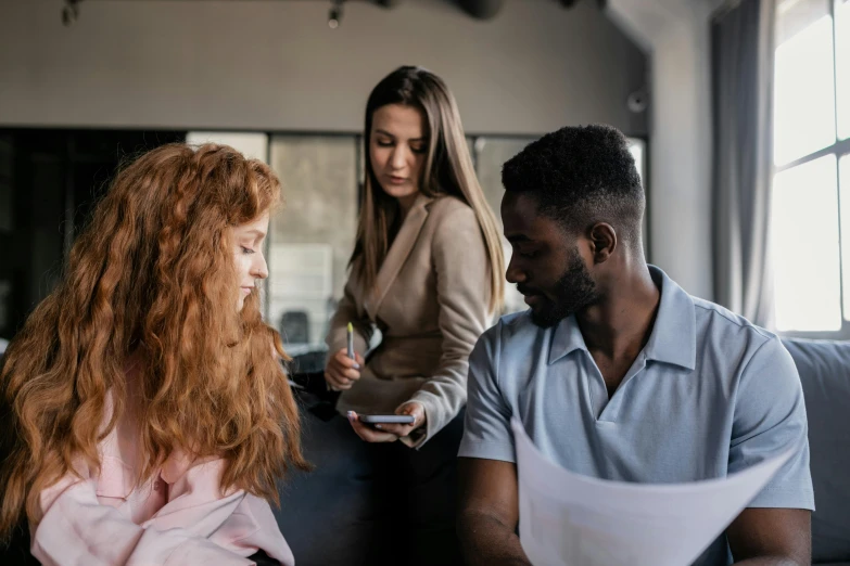 three people sitting on a couch talking to each other, trending on pexels, hr ginger, in a classroom, varying ethnicities, signing a bill