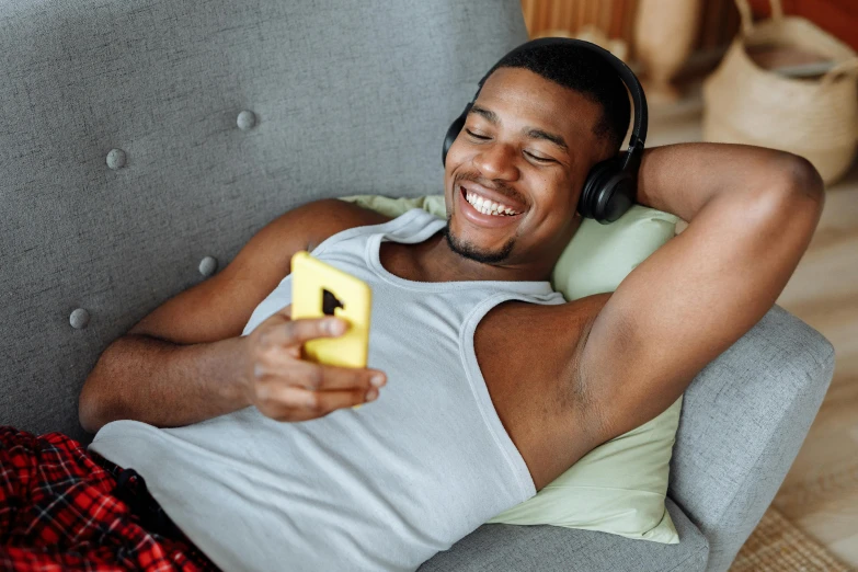 a man laying on a couch listening to music, trending on pexels, avatar image, athletic muscle tone, happy friend, black teenage boy