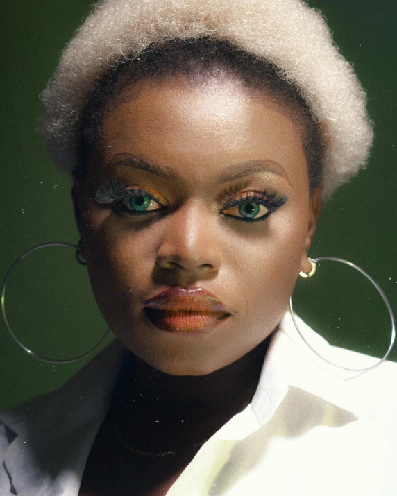 a woman wearing large hoop earrings and a white shirt, an album cover, by Dulah Marie Evans, trending on unsplash, afrofuturism, in a dark green polo shirt, rainbow eyes, close-up portrait film still, lgbtq
