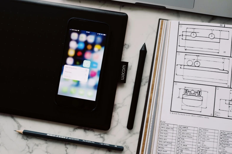 a cell phone sitting on top of a desk next to a laptop, unsplash contest winner, visual art, draw with wacom tablet, architectural plans, dezeen, shot on iphone 6