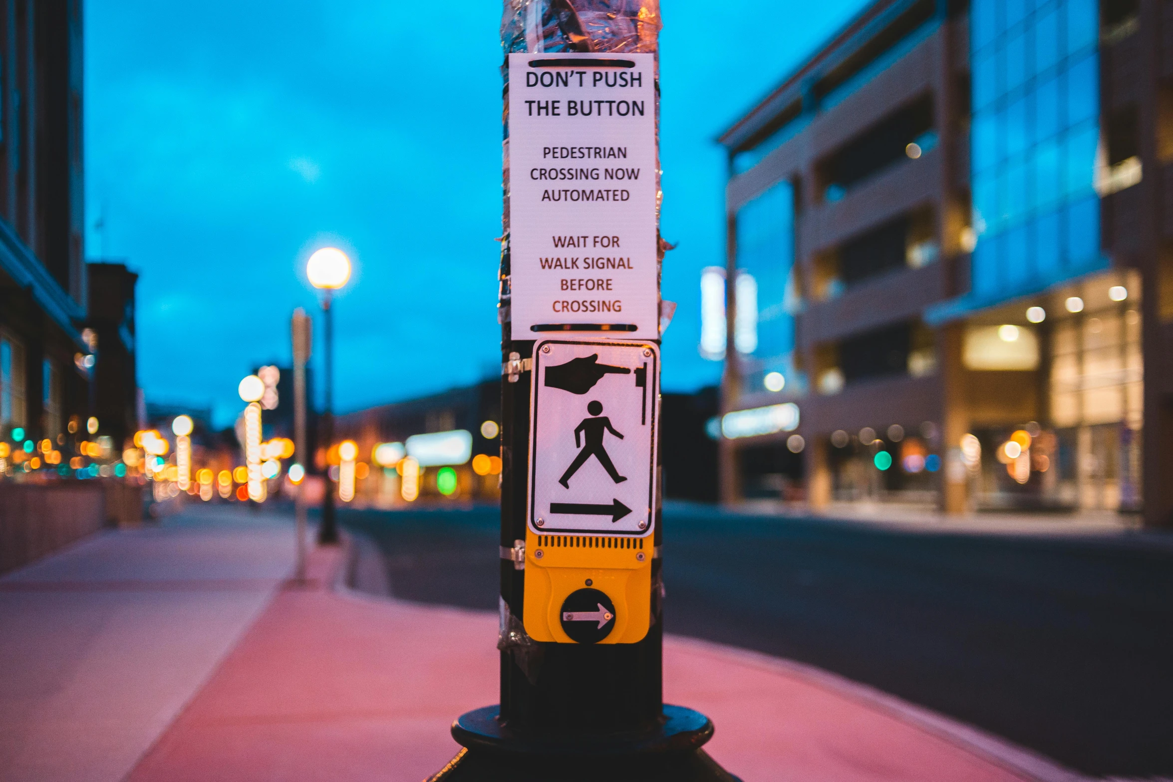 a street sign sitting on the side of a road, a poster, by Julia Pishtar, trending on pexels, crosswalks, vibrant lights, standing upright like people, thumbnail