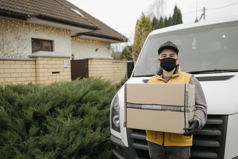 a man wearing a face mask holding a box, pexels contest winner, renaissance, vehicle, avatar image, full length shot, full pallet image