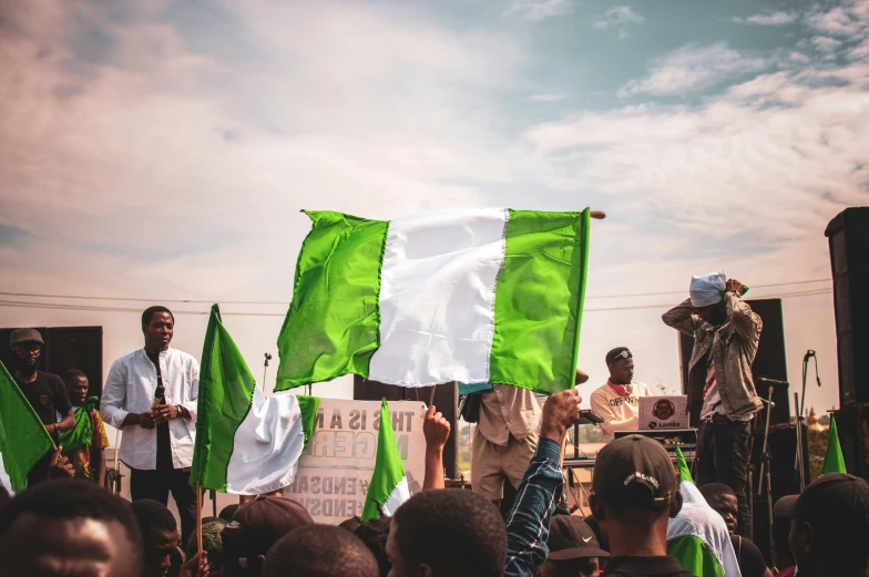 a group of people holding green and white flags, by Matija Jama, pexels contest winner, african canadian, injured, ireland, 🚿🗝📝