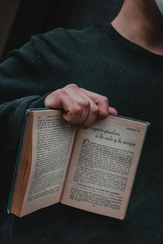 a person holding an open book in their hands, pexels, renaissance, instagram story, ad image, serious, words