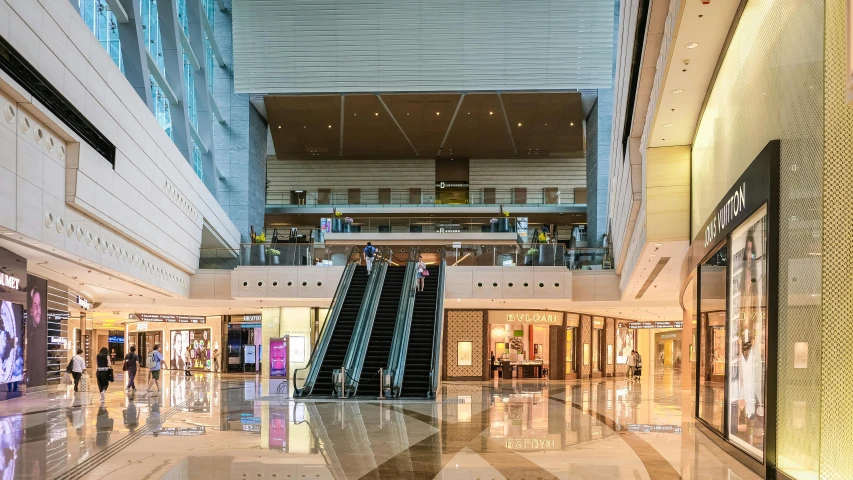 a couple of escalators that are in a building, sitting down, people shopping, inside the building