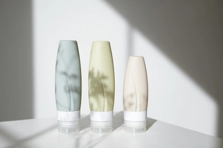 three vases sitting next to each other on a table, inspired by Évariste Vital Luminais, silicone skin, trees in background, sage green, clean face and body skin