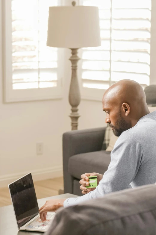 a man sitting on a couch using a laptop, ray lewis, profile image, nvidia promotional image, morning coffee