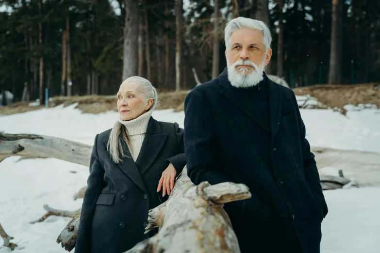 a man and a woman standing next to each other in the snow, a portrait, by Matija Jama, pexels contest winner, silver hair and beard, wooden, still from movie, humans exploring