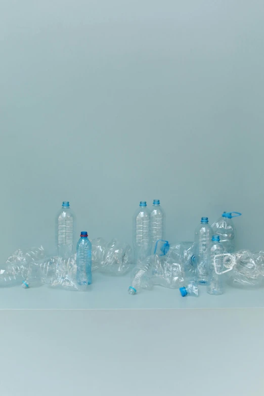 a group of plastic bottles sitting on top of a table, by Maeda Masao, plasticien, plain background, light-blue, album, pollution