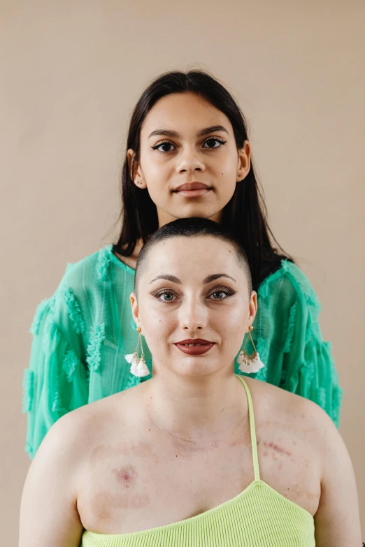 a couple of women standing next to each other, an album cover, by Winona Nelson, trending on pexels, renaissance, shaved face, olive skin, tumours, headshot portrait