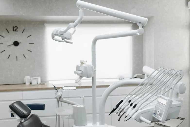 a dentist's chair in a room with a clock on the wall, hurufiyya, titanium white, no - text no - logo, white crown, thumbnail