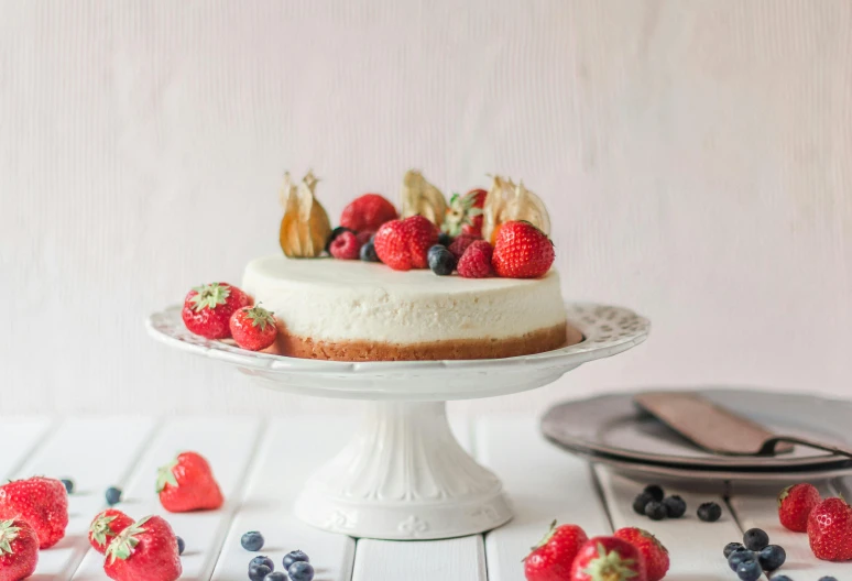 a cake sitting on top of a white cake plate, by Emma Andijewska, pexels contest winner, fruit bowl, background image, cheeses, glossy surface