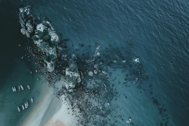 a group of boats floating on top of a body of water, by Daniel Lieske, pexels contest winner, ocean sprites, helicopter view, rock and sand around, high quality screenshot