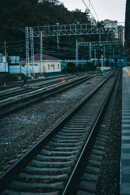 a train traveling down train tracks next to a train station, a picture, by Elsa Bleda, unsplash, square, low quality photo, cinematic footage, urban surroundings