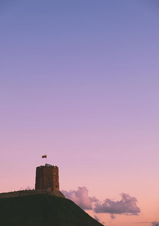 a tall tower sitting on top of a lush green hillside, a portrait, unsplash, romanticism, violet and yellow sunset, flag, 256x256, utrecht